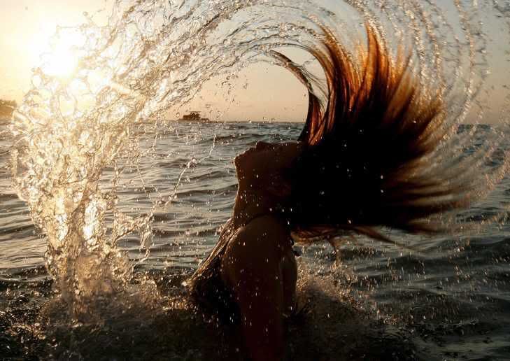 young woman throws her hair back in the Andaman Sea, at a beach on Phuket island in southern Thailand, 17 April 2007, on the last day of the Buddhist new year, or Songkraan water festival Pictures, Images and Photos