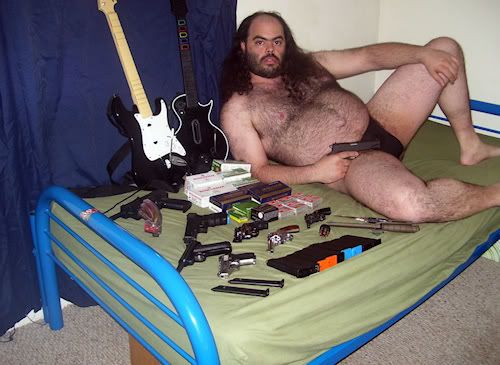 fat_hairy_guy_on_bed_with_guns.jpg